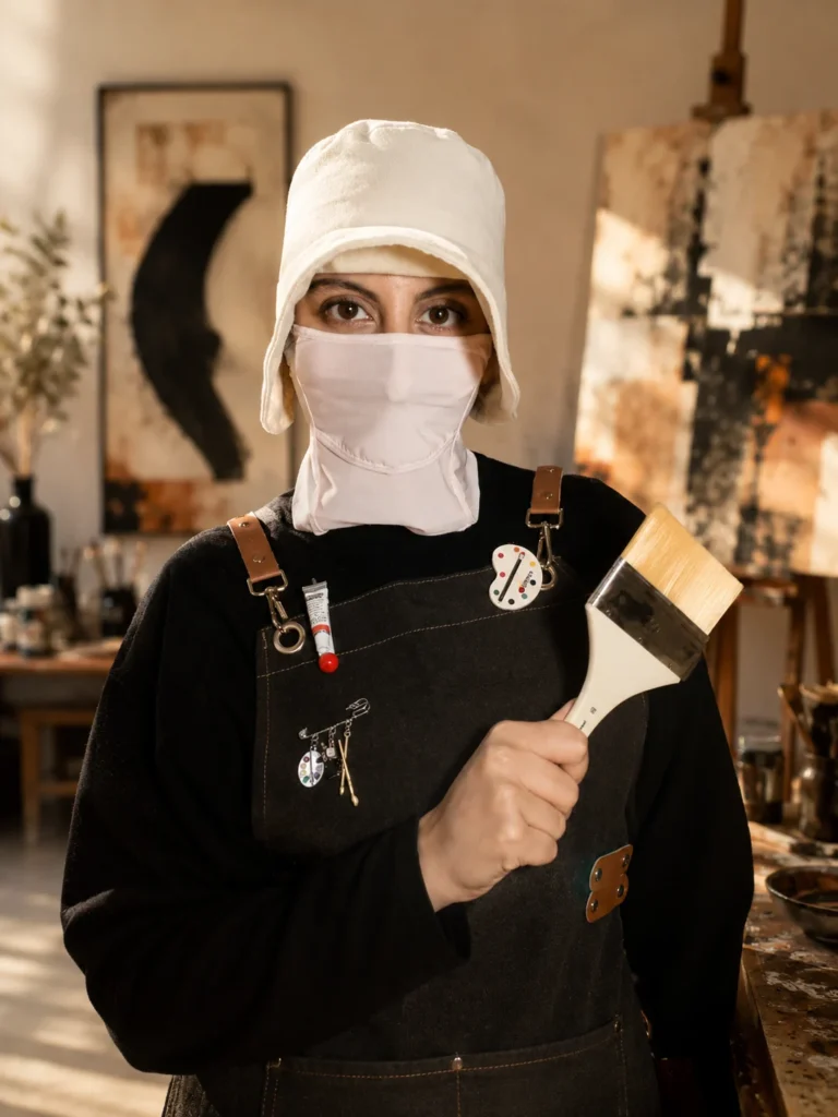 L’artiste Pigment Caché dans son atelier, un pinceau à la main