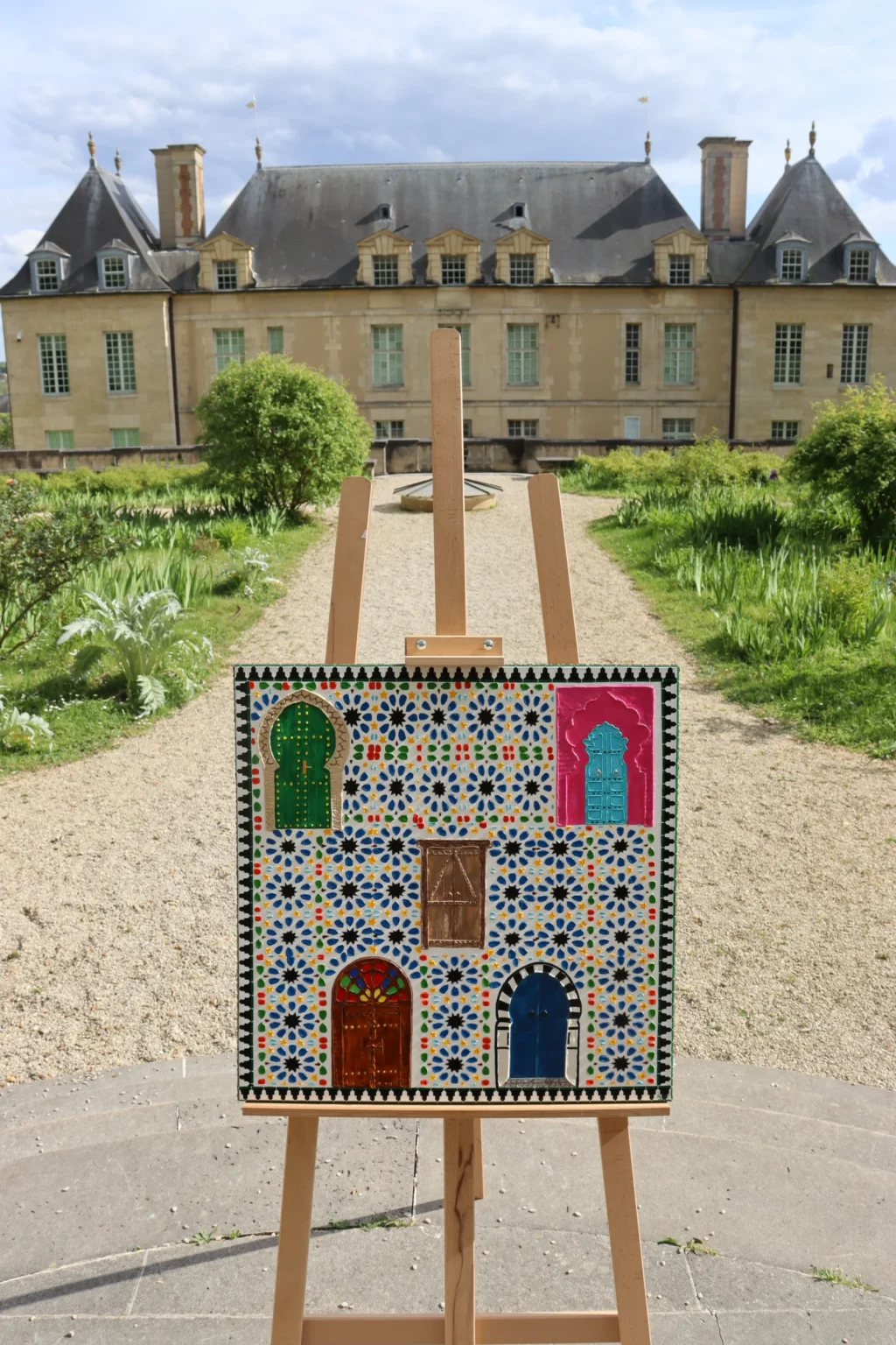 Derrière les Portes, œuvre unique de 60 × 60 cm, vue de face sur son chevalet