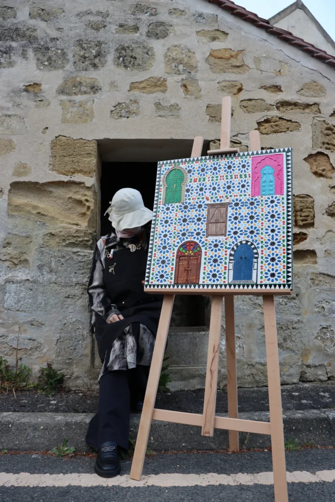 L’artiste et l’œuvre devant une porte ancienne